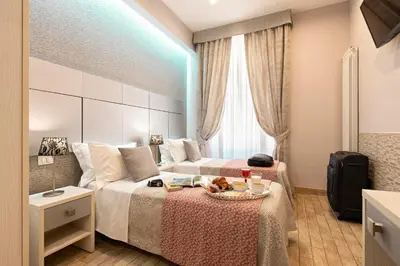 a hotel room with two beds and a table at Five Rooms Rome Guesthouse in Rome