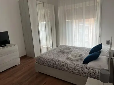 a bedroom with a bed with blue pillows and a television at Stazione Tiburtina - Camesena Apartment in Rome