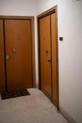 two wooden doors in a hallway with a tile floor at [Centro Storico-5min Vaticano] Domus in Rome