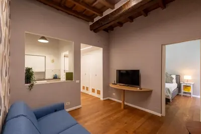 a living room with a blue couch and a television at Roma Centro Storico Luxury - Via del Corso in Rome