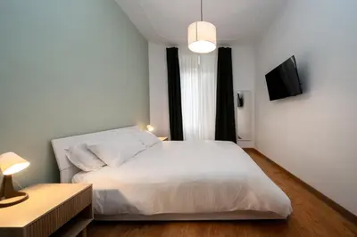 a bedroom with a white bed and a television at VATICAN VIBES in Rome