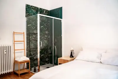 a bedroom with a bed and a glass shower at VATICAN VIBES in Rome