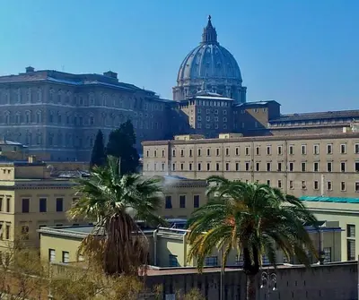 a large building with a dome on top of it with palm trees at VATICAN DESIGN APARTMENTS in Rome
