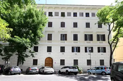 a white building with cars parked in front of it at VATICAN DESIGN APARTMENTS in Rome
