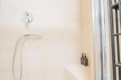 a shower with a shower head in a bathroom at Via Giulia Charming Atelier apartment in Rome