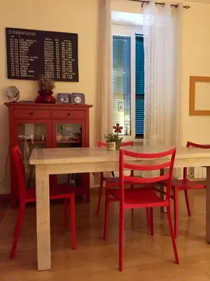 a dining room with a table and red chairs at Roma Da Noi Suite in Rome