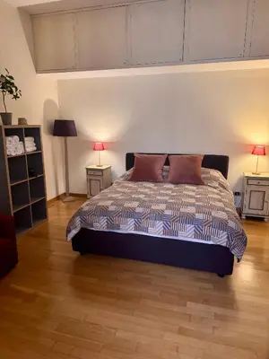 a bedroom with a bed with two lamps and two tables at Roma Da Noi Suite in Rome