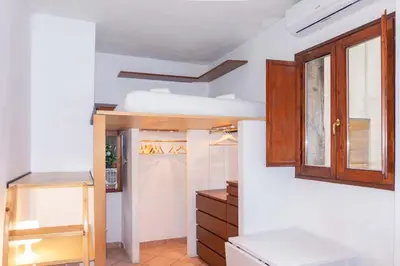 a room with a bed and a wooden cabinet at EasyTopStay - Monti Studio Apartment in Rome