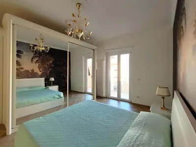 a bedroom with a large bed and a chandelier at Oasi Urbana San Paolo in Rome