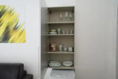a pantry with plates and cups and dishes on shelves at Ermete Vatican House in Rome