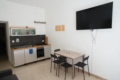 a kitchen with a table and chairs and a television at Ermete Vatican House in Rome