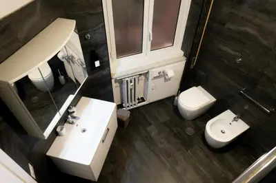 a bathroom with a sink and a toilet and a mirror at Ermete Vatican House in Rome