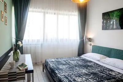 a bedroom with a bed and a table and a window at St Peter's View in Rome