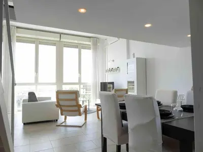 a kitchen with white chairs and a dining room with a table at Window on Rome in Rome