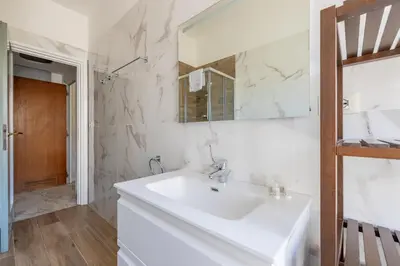 a white bathroom with a sink and a mirror at White Suite in Rome in Rome