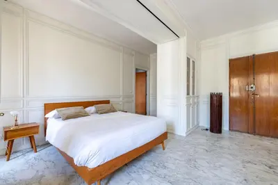 a bedroom with a large bed and a wooden cabinet at White Suite in Rome in Rome