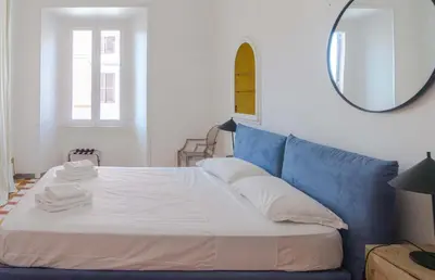 a bedroom with a blue couch and a mirror at EasyTopStay - Villa Borghese Large Apartment in Rome