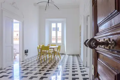 a room with a table and chairs on a checkered floor at EasyTopStay - Villa Borghese Large Apartment in Rome