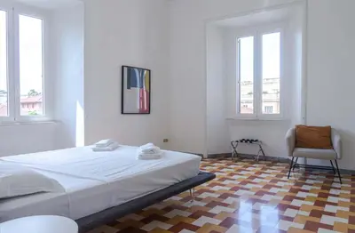 a white bedroom with a bed and a chair at EasyTopStay - Villa Borghese Large Apartment in Rome