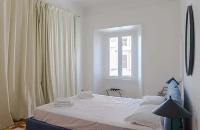 a white bedroom with a bed and a window at EasyTopStay - Villa Borghese Large Apartment in Rome