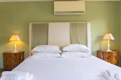 a bedroom with a large white bed with two lamps at EasyTopStay - Piazza Venezia Charming & Bright Apt in Rome