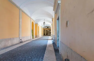 an empty hallway of a building with an arcade at EasyTopStay - Piazza Venezia Charming & Bright Apt in Rome