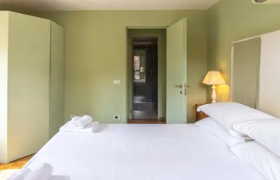 a bedroom with a large white bed and a lamp at EasyTopStay - Piazza Venezia Charming & Bright Apt in Rome