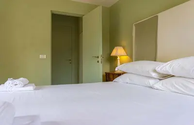 a large white bed in a room with a lamp at EasyTopStay - Piazza Venezia Charming & Bright Apt in Rome
