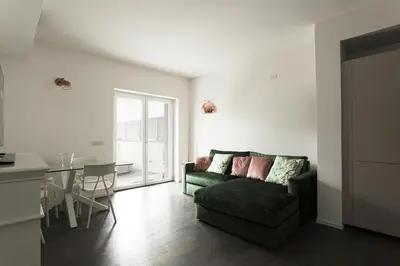 a living room with a green couch and a table at EasyTopStay - Stylish Flat with Garden in Rome