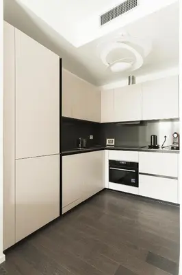 a white kitchen with black and white cabinets at EasyTopStay - Stylish Flat with Garden in Rome