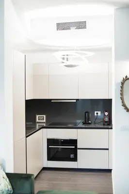 a kitchen with white cabinets and a stove top oven at EasyTopStay - Stylish Flat with Garden in Rome