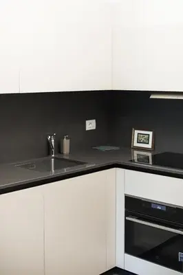 a kitchen with white cabinets and a sink at EasyTopStay - Stylish Flat with Garden in Rome