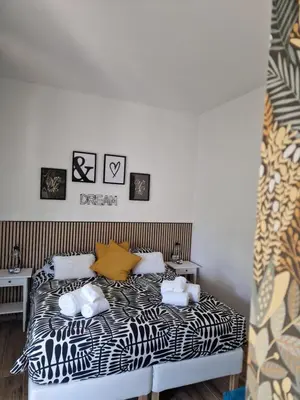 a bedroom with a bed with black and white sheets at Home K&Y Élite in Rome