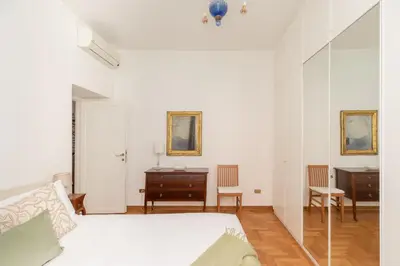 a white bedroom with a bed and a desk at iFlat Red Roman Apartament in Rome