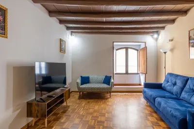 a living room with a blue couch and a tv at woodstyle apartment - navona in Rome