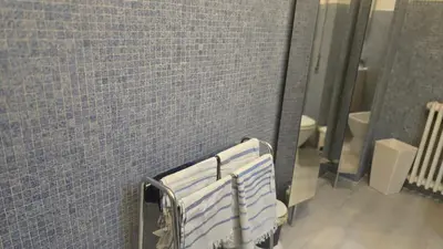a bathroom with a blue tile wall and a mirror at Home Rome Center in Rome