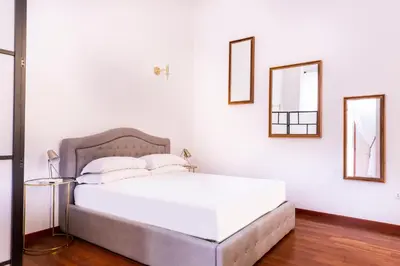 a bedroom with a large white bed with two mirrors at Casa Salandra by Hili in Rome