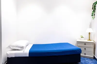 a bed with a blue blanket and a night stand at Casa Salandra by Hili in Rome