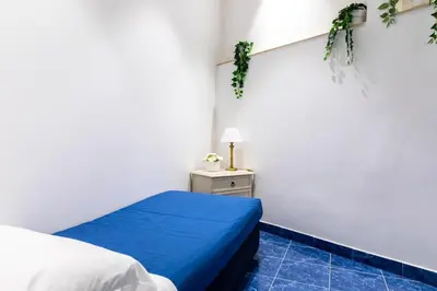 a bedroom with a bed and a nightstand with a blue floor at Casa Salandra by Hili in Rome