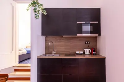 a kitchen with black cabinets and a sink at Casa Salandra by Hili in Rome