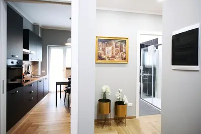 a kitchen and a living room with white walls at VATICAN HOME ROMA in Rome
