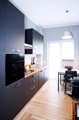 a kitchen with black cabinets and a dining room at VATICAN HOME ROMA in Rome