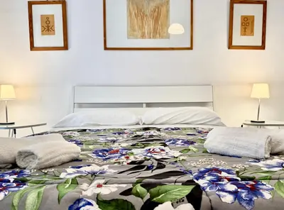 a bedroom with a bed with a floral quilt at Ottaviano - 10 min dal Vaticano in Rome