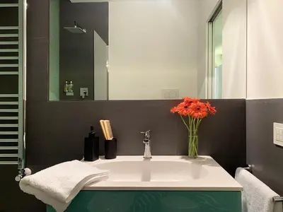 a bathroom with a sink with a vase of flowers at ARCAsuite Tritone Luxury in Rome