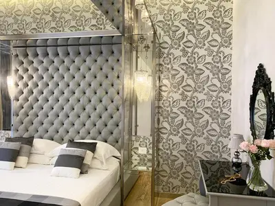 a bedroom with a large bed with a padded headboard at ARCAsuite Tritone Luxury in Rome