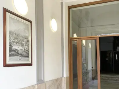 a painting on a wall next to a glass door at ARCAsuite Tritone Luxury in Rome