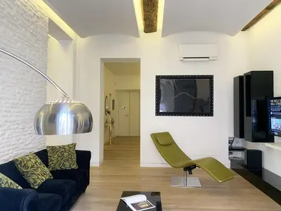 a living room with a couch and a chair at ARCAsuite Tritone Luxury in Rome