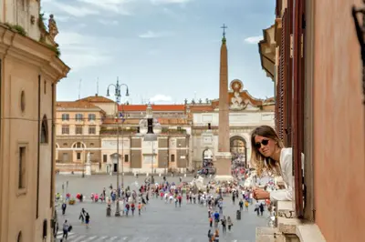 a woman looking out of a window at a city at Tridente Suites in Rome