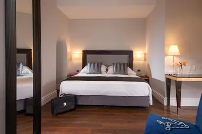 a hotel room with a bed and a mirror at Tridente Suites in Rome