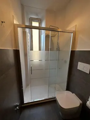 a bathroom with a toilet and a glass shower at 2MG: appartamento con terrazzo nel cuore di Roma! in Rome